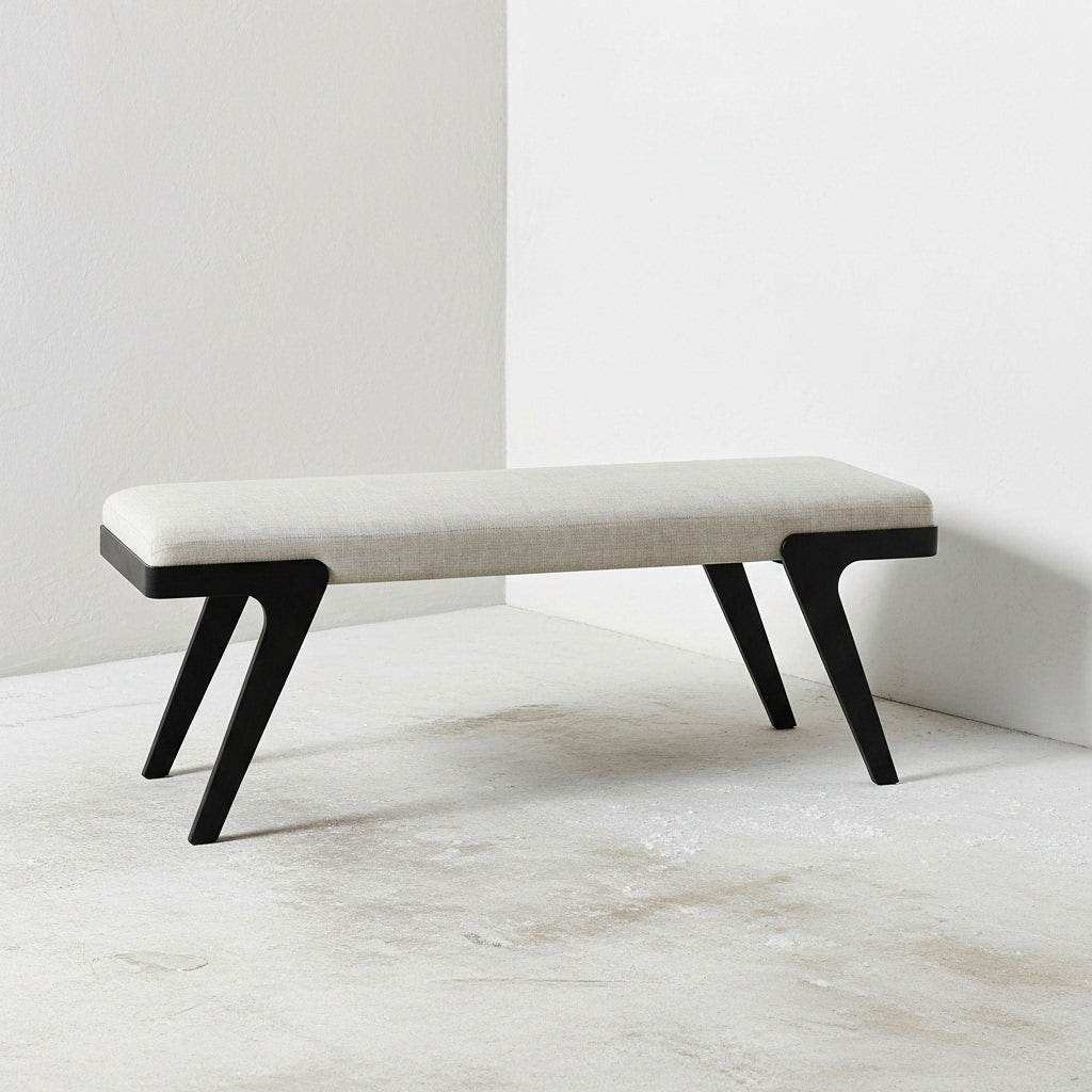 Bench with black legs and white cushion on a light wooden floor.