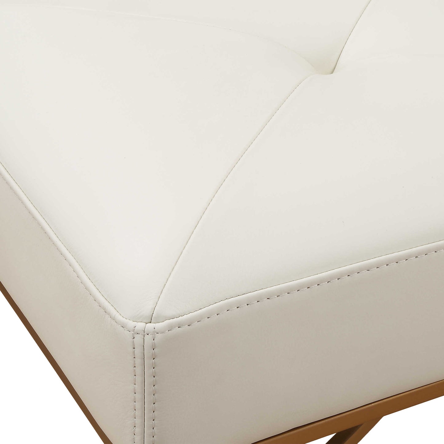 Close up shot of white upholstered bench with gold metal frame