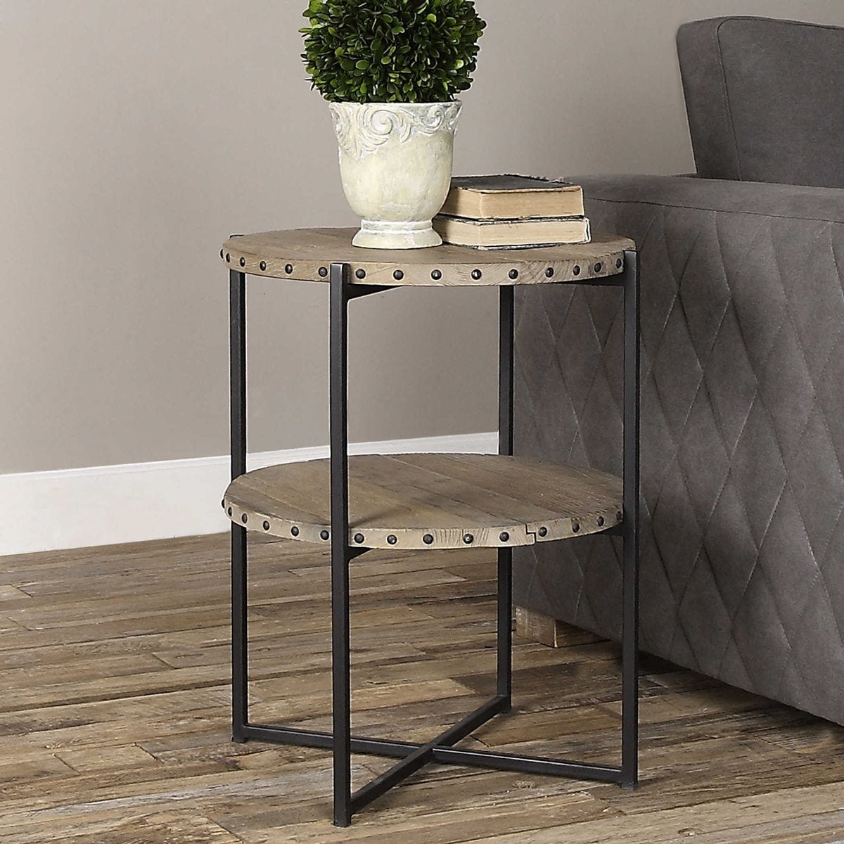 Two-tiered side table with metal frame and wooden shelves next to a gray sofa.