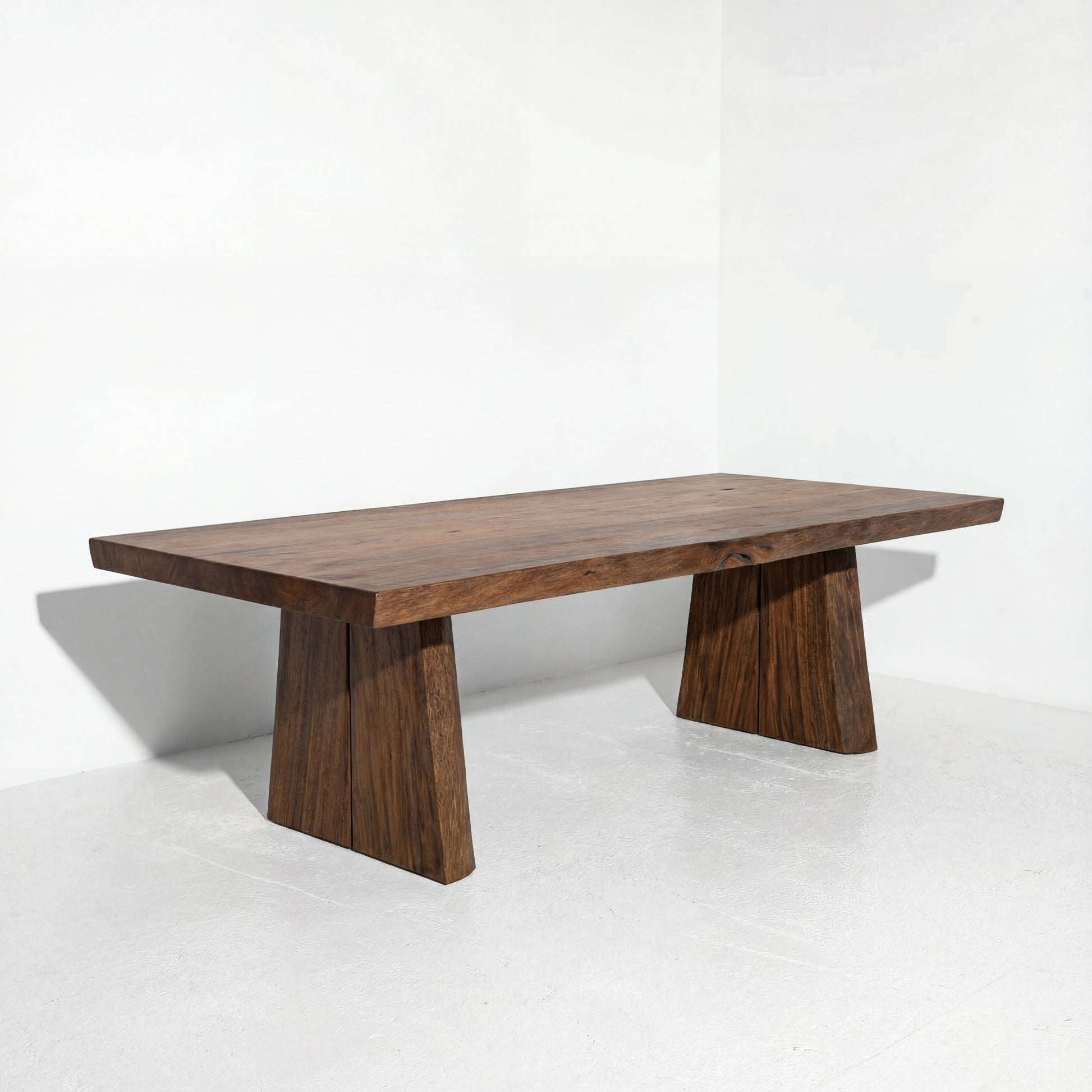 Wooden coffee table with unique base design on a white background