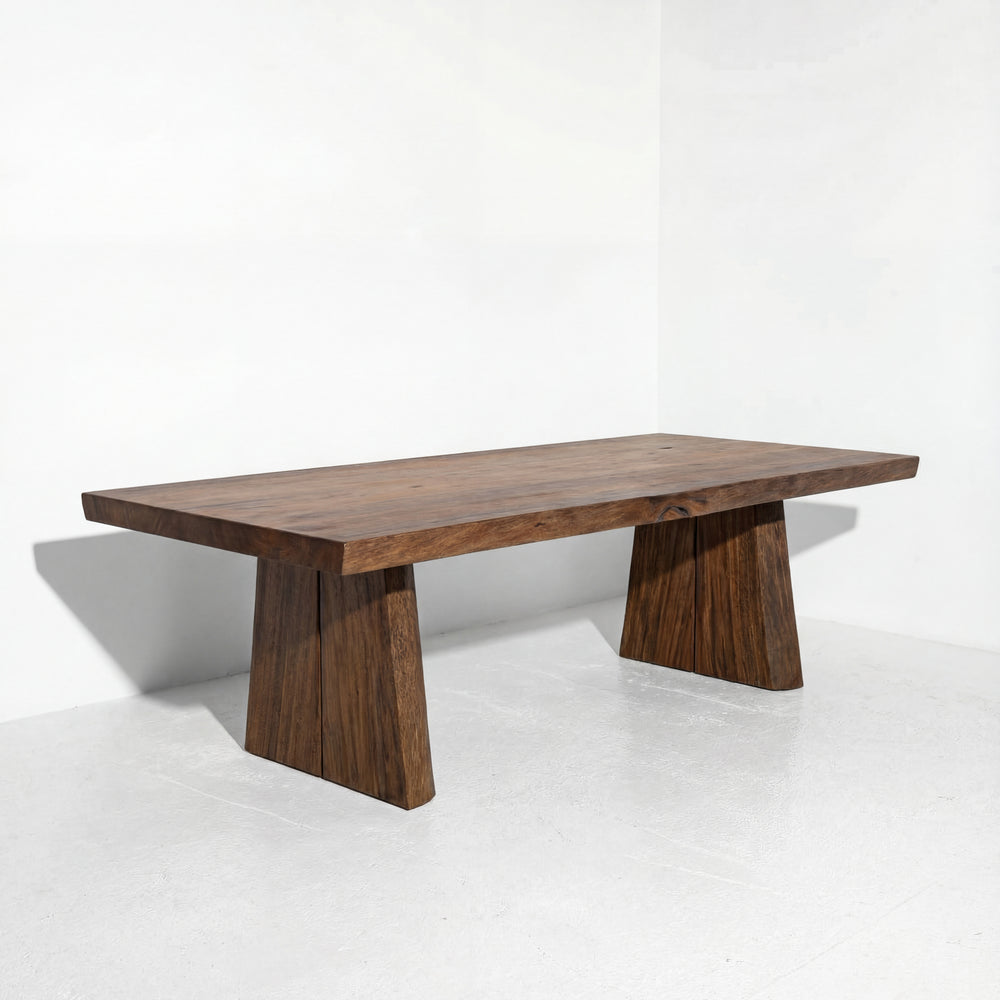 Wooden coffee table with unique base design on a white background