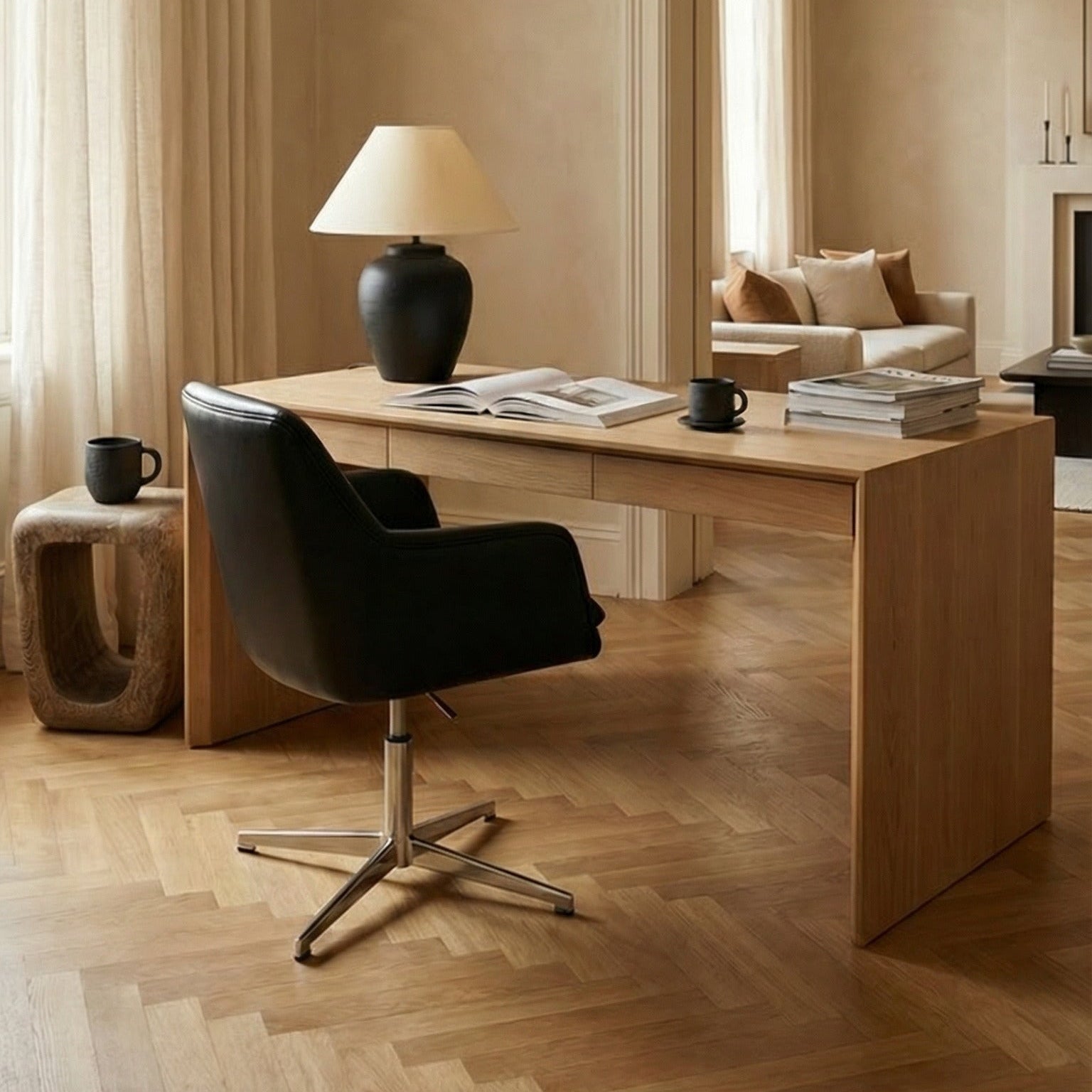 Modern home office with a desk, chair, and chandelier. There is a wood accent stool next to the desk.