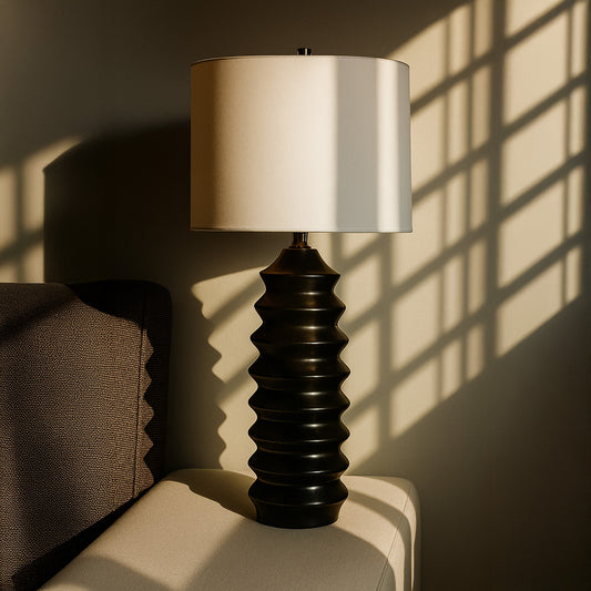 Table lamp with textured black base and white shade on a white background