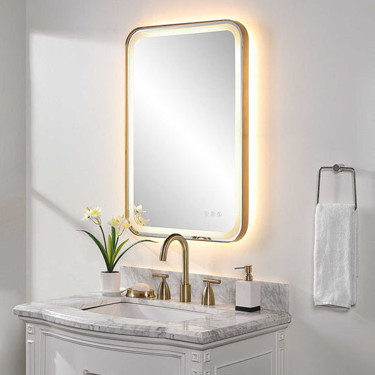 Gold vanity mirror with lights over a white marble vanity in a bathroom.