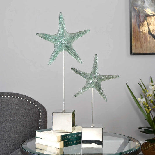 Realistic starfish replicas feature a pale, marine green finish and sit atop tarnished silver stands