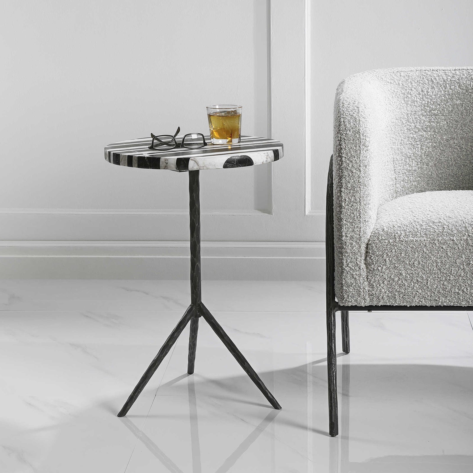Zebra marble top with scotch on top and glasses next to a classic modern armchair.