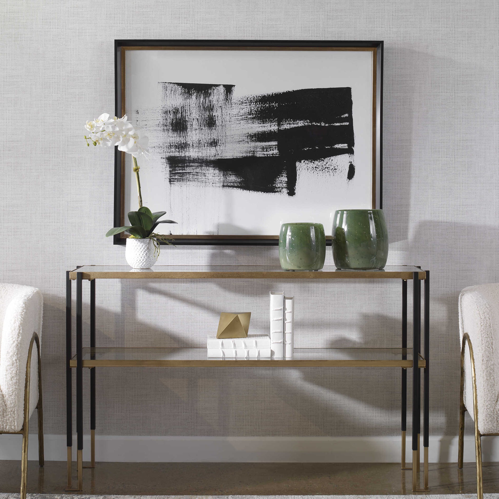 Stunning black and white running man framed print over a glass console in front of some green jars and a white orchid. 