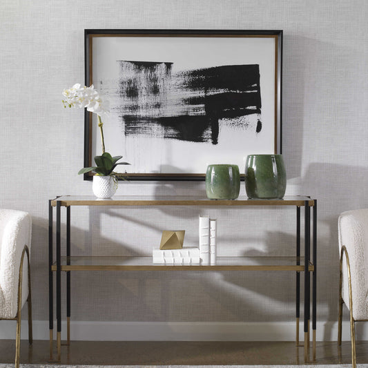 Stunning black and white running man framed print over a glass console in front of some green jars and a white orchid.