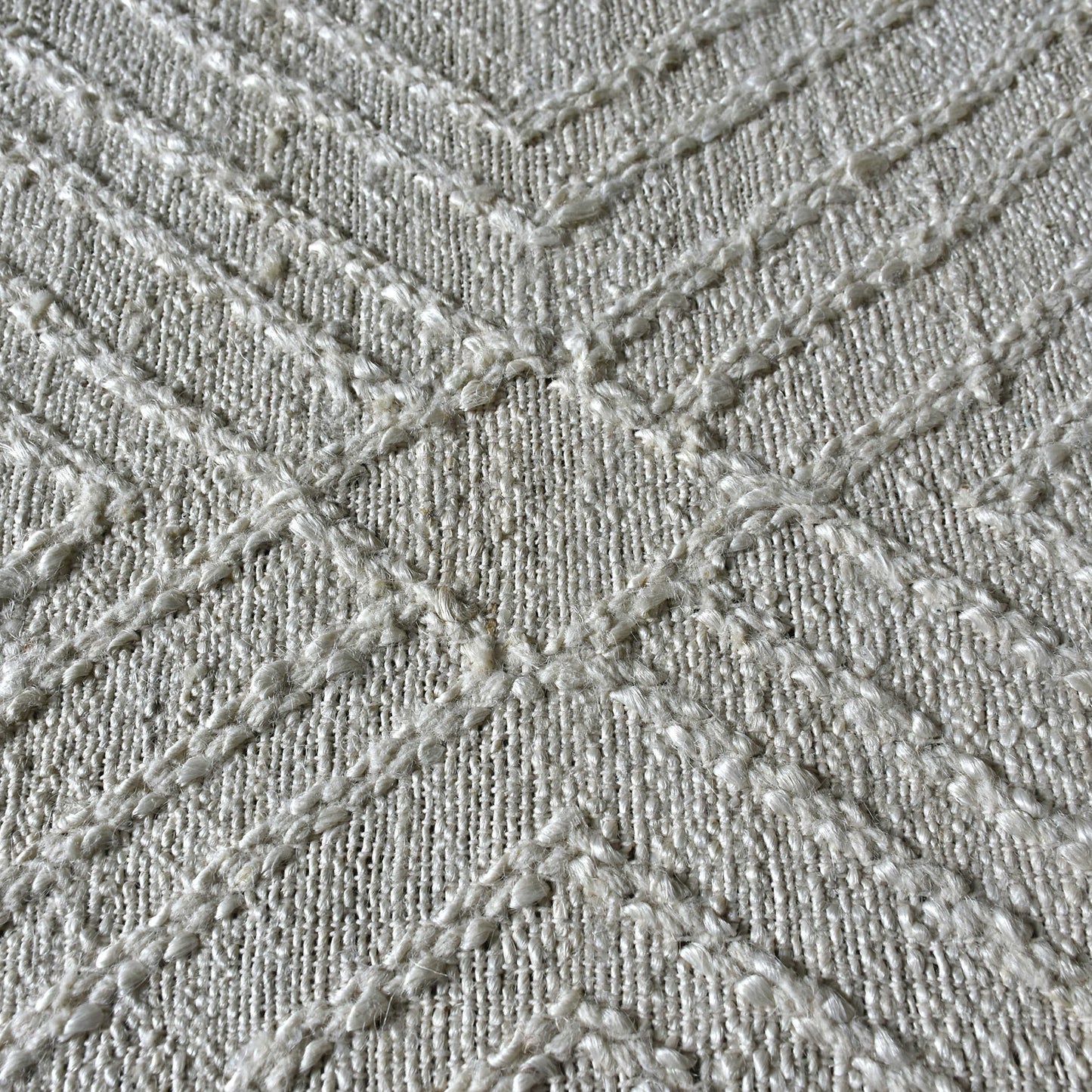 Raised geometric white pattern of the wool white rug. 