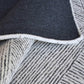 close-up shot of navy underside of rug and white and gray top geometric pattern