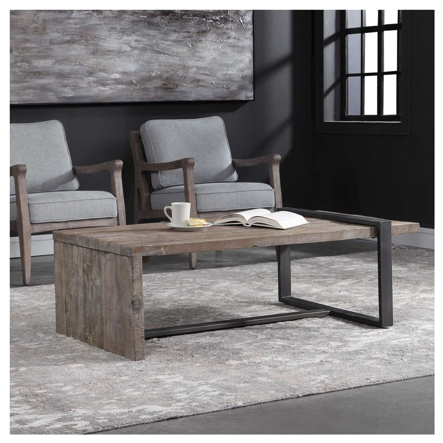 This shows this reclaimed wood and iron rectangle coffee table in a room setting with chairs and art in background.