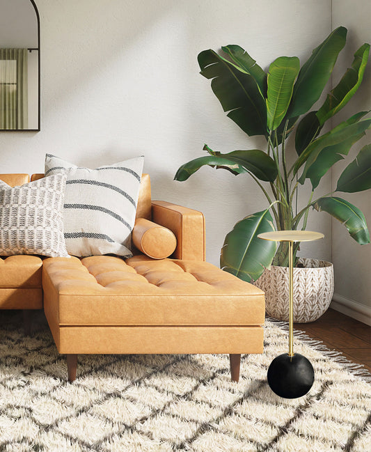 Gold accent table next to couch orange couch in an elevated, upscale living room.