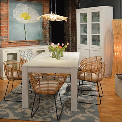 White Farmhouse Table with four chairs and a rug underneath that is blue. 