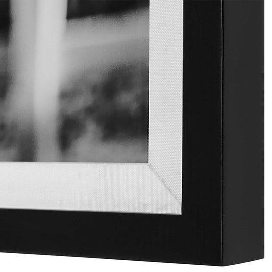 A framed black and white photograph of two horses wearing bridles, displayed in a modern interior setting.