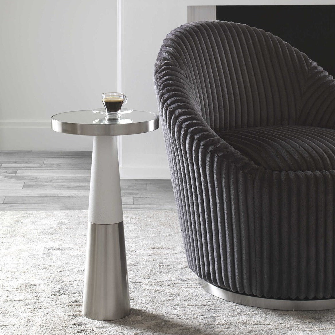 Silver contemporary drink table in neural living room with white walls and gray decorative armchair. 